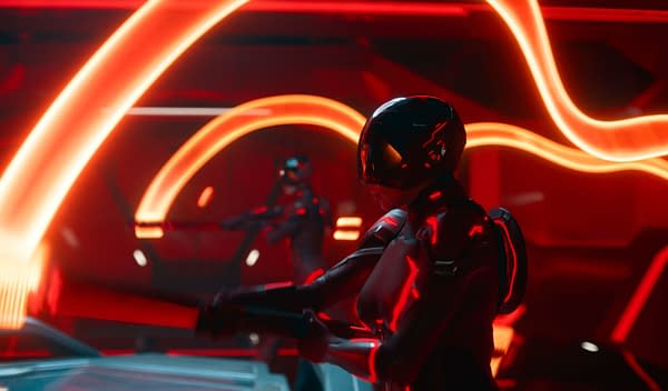 A scene from Disney's live-action movie TRON: ARES, featuring two figures in futuristic armor illuminated by glowing red light patterns, set against a high-tech backdrop.