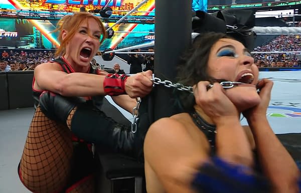A wrestler with red hair in a black outfit, Becky Lynch, aggressively pulls a chain attached to another wrestler, Lyra Valkyrie, who appears to be in distress. The background shows a wrestling ring surrounded by fans at WWE SummerSlam.
