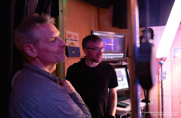 Behind-the-scenes photo of two crew members on the set of Shaun the Sheep: The Beast of Mossy Bottom, standing by a monitor and studio lighting.