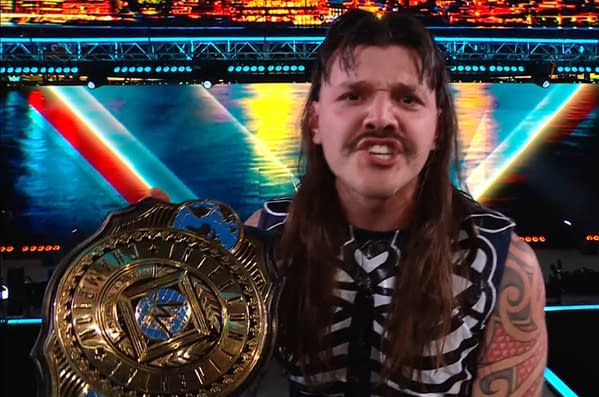 Dominik Mysterio enthusiastically celebrates his victory, holding a championship belt, while wearing a skeleton-themed outfit. The background features vibrant lights and colors, enhancing the celebratory atmosphere.