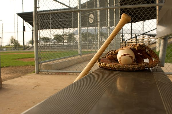 Baseball Glove, Ball, and Bat in Dugout -- David Lee/Shutterstock.com