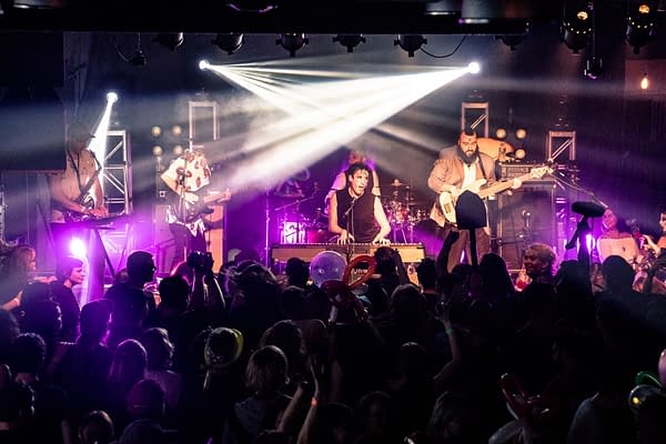 A photograph of Will Wood and the Tapeworms performing in front of a packed crowd.