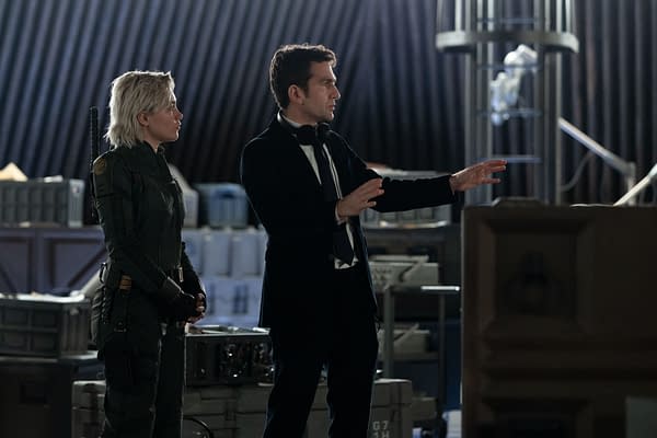 Behind-the-scenes image featuring Florence Pugh in a military-style outfit and director Jake Schreier gesturing as they work on the set of Marvel Studios' 'Thunderbolts.'