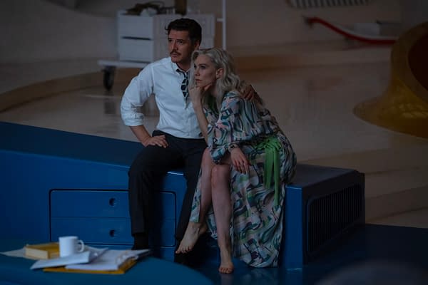Still from 'The Fantastic Four: First Steps' featuring Pedro Pascal as Reed Richards and Vanessa Kirby as Sue Storm, seated together on a blue surface in a futuristic setting.