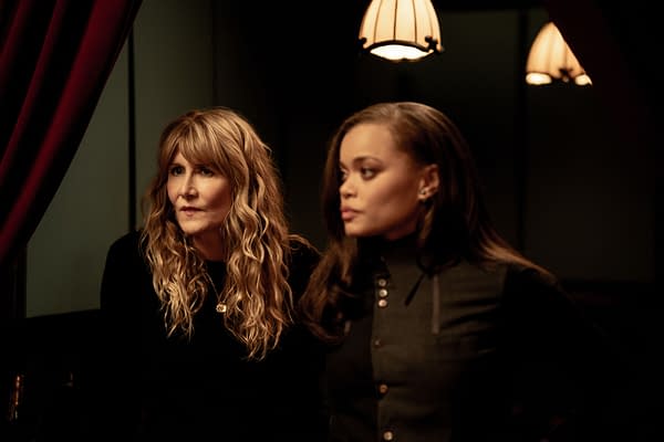 A portrait of Laura Dern and Andra Day in a dimly lit setting, both looking thoughtfully ahead. The atmosphere is intimate, with warm lighting and rich red curtains in the background.