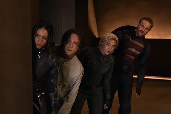 A promotional still from Marvel Studios' 'Thunderbolts' featuring four characters: Ghost, Bob, Yelena Belova, and John Walker, peeking around a corner with expressions of concern. The scene suggests tension or suspense.