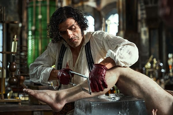 Oscar Isaac as Victor Frankenstein performs a surgical procedure in a laboratory setting, highlighting a moment of intense focus and the dramatic atmosphere of the film 'Frankenstein.'