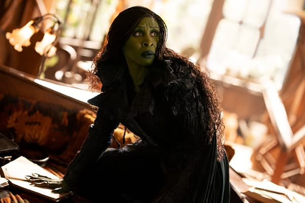 Cynthia Erivo portrays Elphaba in the film 'WICKED FOR GOOD,' wearing a dark, textured costume and exhibiting a serious expression in a richly decorated setting.
