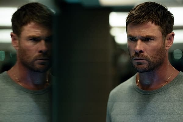 Chris Hemsworth stars as a serious character named Davis in the crime drama 'Crime 101,' with a contemplative expression, reflected partially in a mirror that highlights his intense demeanor.