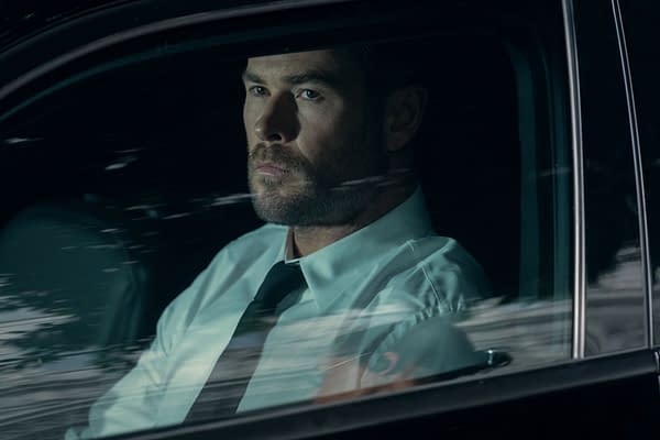 Chris Hemsworth stars as a character named Davis, seated inside a car with a serious expression, wearing a light blue shirt and black tie, creating an intense atmosphere.