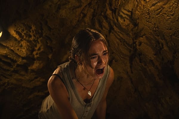 Johnny Sequoyah as Lucy, in a dramatic scene from the film Primate, is shown screaming, with a dimly lit background that suggests a cave or underground setting.