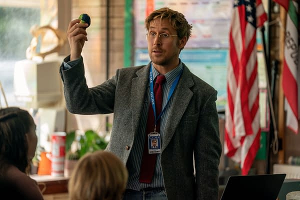 Ryan Gosling portrays Ryland Grace in a classroom setting, holding a small globe while addressing his students. The environment includes various educational materials and flags.