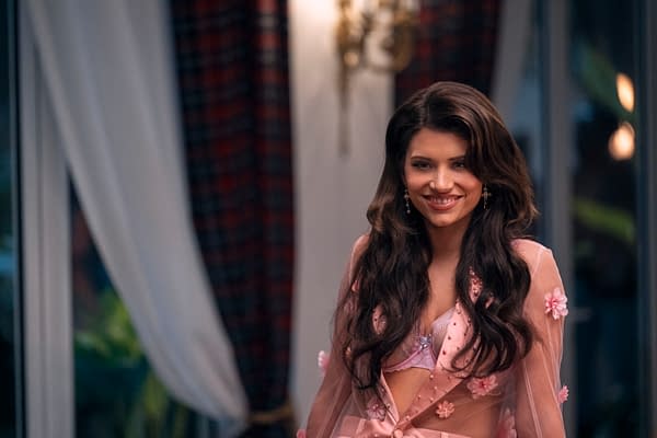 Emilia, portrayed by Eva De Dominici in the film 'Balls Up,' smiles while wearing a floral-embellished pink outfit in an elegant setting. Soft lighting and muted colors enhance the atmosphere of the scene.