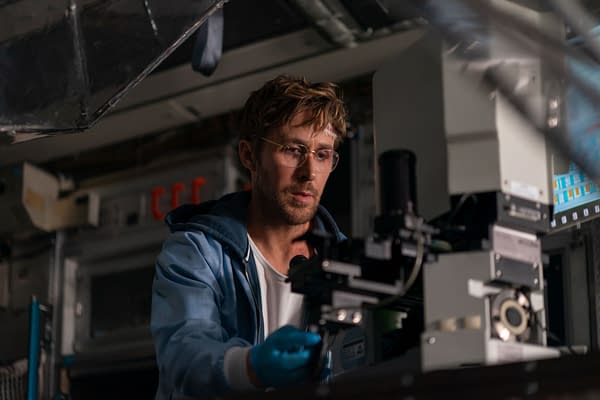 Ryan Gosling portrays Ryland Grace, focused on scientific equipment in a high-tech environment, in a key set from 'Project Hail Mary.' This scene highlights the use of practical effects in the film.