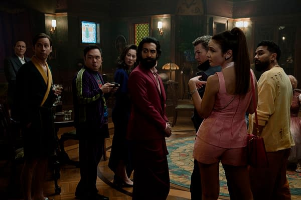 A scene from 'READY OR NOT 2: HERE I COME' featuring a group of diverse individuals, including Kara Wooten and Varun Saranga, dressed in stylish outfits, standing in a dimly lit, elegant room with vintage decor.