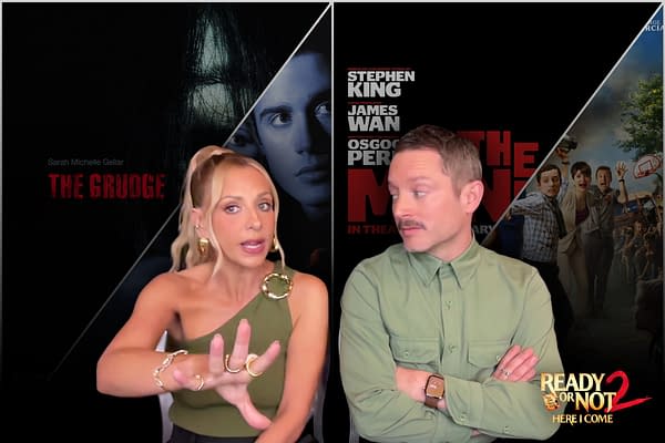 Sarah Michelle Gellar and Elijah Wood discuss horror films, with promotional images of 'The Grudge' and 'Ready Or Not 2' in the background. Gellar is gesturing with her hands while wearing a stylish top and large earrings, while Wood looks attentively at her.