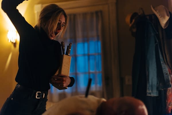 A woman holding a block of kitchen knives raises her arm as if about to strike, displaying a look of fear and anger. The background is dimly lit, hinting at a tense and dramatic scene.