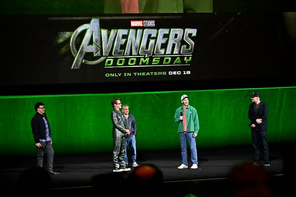 Kevin Feige, Anthony Russo, Joe Russo, Robert Downey Jr., and Chris Evans stand onstage at CinemaCon in front of a large Avengers: Doomsday Marvel Studios title screen.