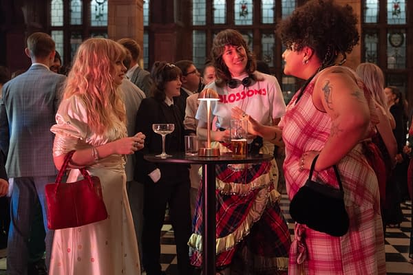 Angourie Rice, Amber Grappy, and Alicia MacDonald talk at a cocktail table on the set of Finding Emily during a crowded indoor party scene.