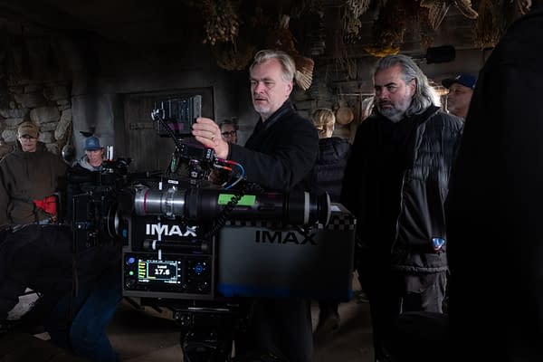 Christopher Nolan and cinematographer Hoyte van Hoytema on the set of The Odyssey, standing beside a large IMAX camera.