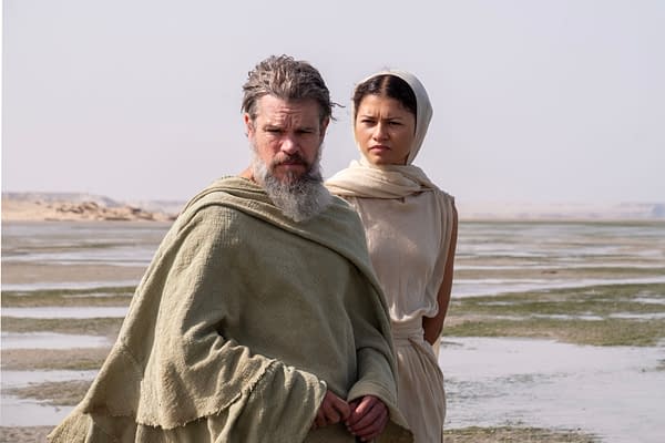 Matt Damon as Odysseus and Zendaya as Athena stand together in desert-like coastal scenery in The Odyssey.