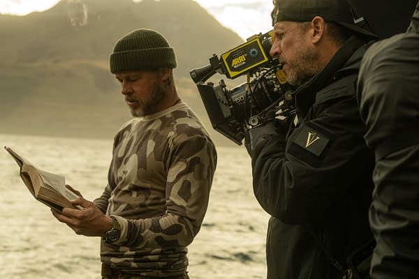 Brad Pitt stands by the water reading from a script while director David Ayer films him with an ARRI camera on the set of Heart of the Beast.