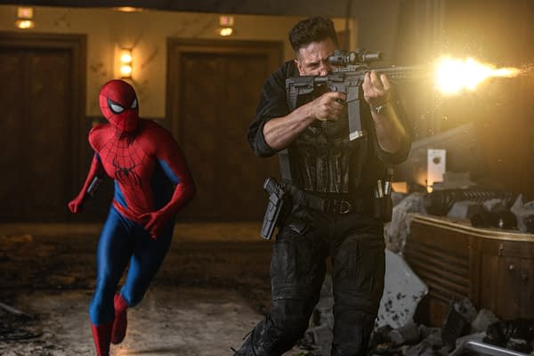 Spider-Man runs through a hotel hallway as a man in tactical gear fires a rifle, creating a bright muzzle flash.