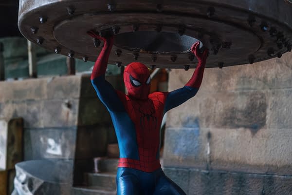 Spider-Man in his red-and-blue suit holds up a large metal structure overhead in an action scene from Spider-Man: Brand New Day.