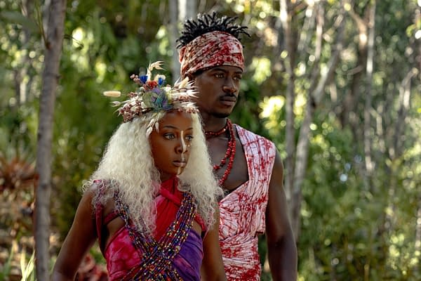 Thuso Mbedu and Damson Idris stand in elaborate tribal-inspired costumes in a forest setting from Children of Blood and Bone.