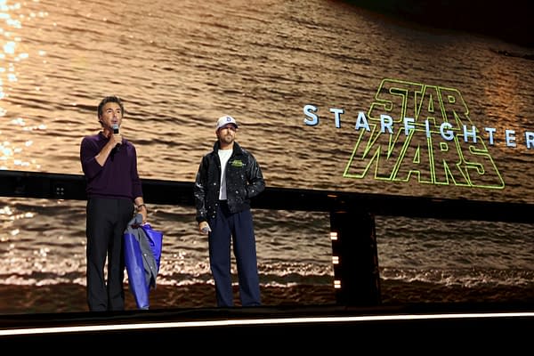 Shawn Levy and Ryan Gosling onstage at Disney Entertainment Showcase, speaking beside a large Star Wars: Starfighter logo backdrop.