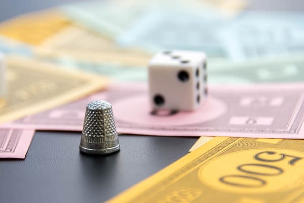 Monopoly thimble, dice and money photo by CaseyMartin / Shutterstock.com.