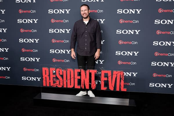 Zach Cregger poses on the red carpet at CinemaCon 2026, standing next to a bold 'RESIDENT EVIL' sign, with a backdrop featuring the Sony Pictures logo.