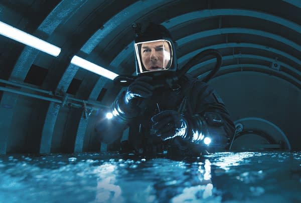 A scene from 'Mission: Impossible - The Final Reckoning' featuring a character in a dark, futuristic environment, wearing a diving suit and helmet with lights, conveying a sense of urgency and action.