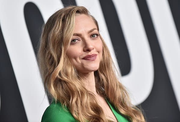 Amanda Seyfried poses with a subtle smile on the red carpet, wearing a green outfit. The image captures the glamour of a celebrity event, highlighting her as a prominent figure in the entertainment industry.