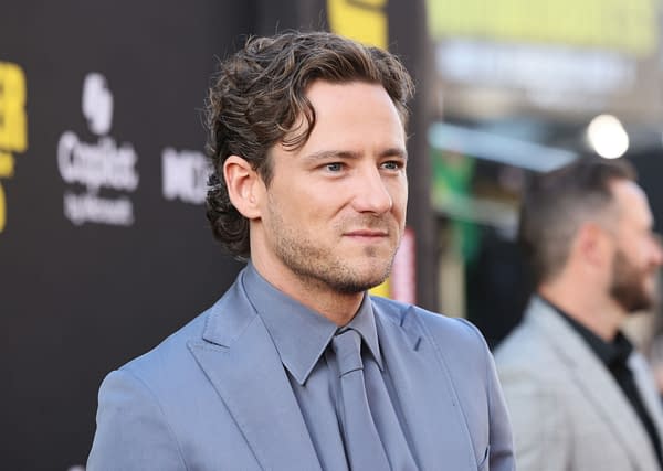 Lewis Pullman is seen attending the World Premiere of Marvel Studios' "Thunderbolts," wearing a light blue suit and gray tie, against a black backdrop. The event took place at the Dolby Theatre in Hollywood.