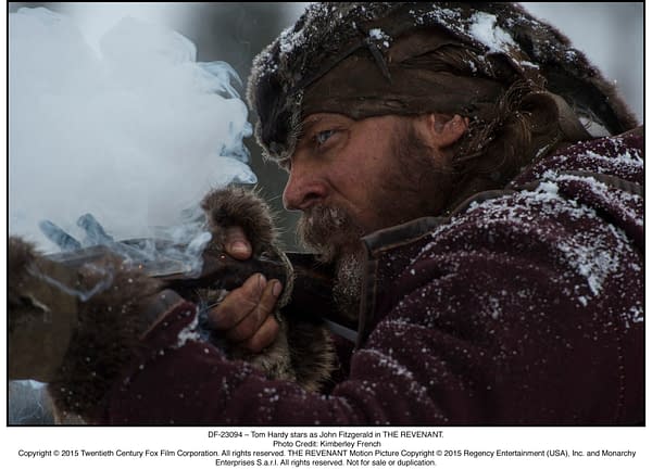 A close-up of a rugged man, Tom Hardy as John Fitzgerald in THE REVENANT, aiming a rifle while smoke billows from the barrel, suggesting a tense moment. Snow covers his hair and clothing, emphasizing the harsh environment.