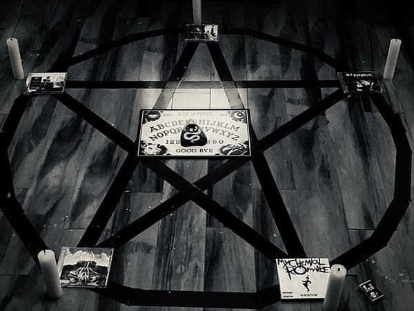 A photographic still from My Chemical Romance, featuring their albums in a summoning pentagram.