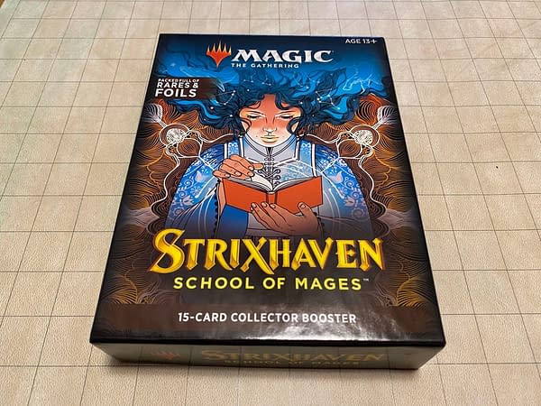 The packaging for the Collector Booster packs from Magic: The Gathering's Strixhaven: School of Mages expansion set. Note that the squares on the grid background are in inches.