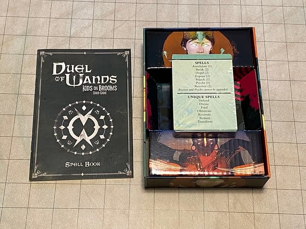 The full gamut of the component contents of the Duel of Wands card game by Renegade Game Studios includes 45 cards for gameplay, two spell reference cards, and a rulebook.
