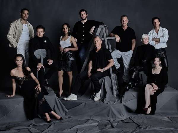 Group portrait of the cast from 'Wake Up Dead Man: A Knives Out Mystery,' featuring actors Mila Kunis, Daryl McCormack, Jeremy Renner, Kerry Washington, Josh O'Connor, Daniel Craig, Josh Brolin, Glenn Close, Andrew Scott, and Cailee Spaeny, posed against a dark backdrop.