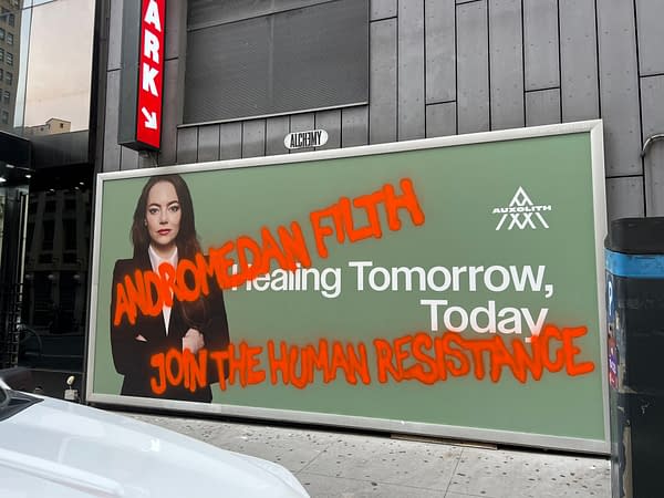 A billboard features a woman in a black suit with long, wavy hair, promoting a message that reads 'Healing Tomorrow, Today.' The text is partially obscured by graffiti stating 'ANDROMEDAN FILTH' and 'JOIN THE HUMAN RESISTANCE,' creating a striking visual contrast.