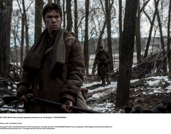 Will Poulter as Jim Bridger, a legendary mountain man, stands in a snowy forest holding a rifle, with a rugged, weathered appearance, reflecting the harsh environment of the film THE REVENANT.
