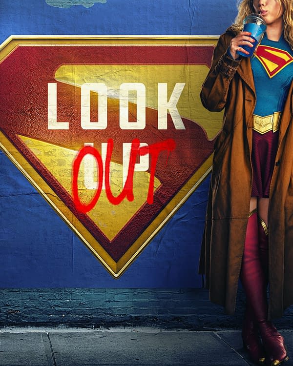 A promotional poster featuring a person dressed as Supergirl standing beside a large Supergirl emblem. The words "LOOK OUT" are spray-painted in red across the emblem, suggesting an urban, edgy theme.