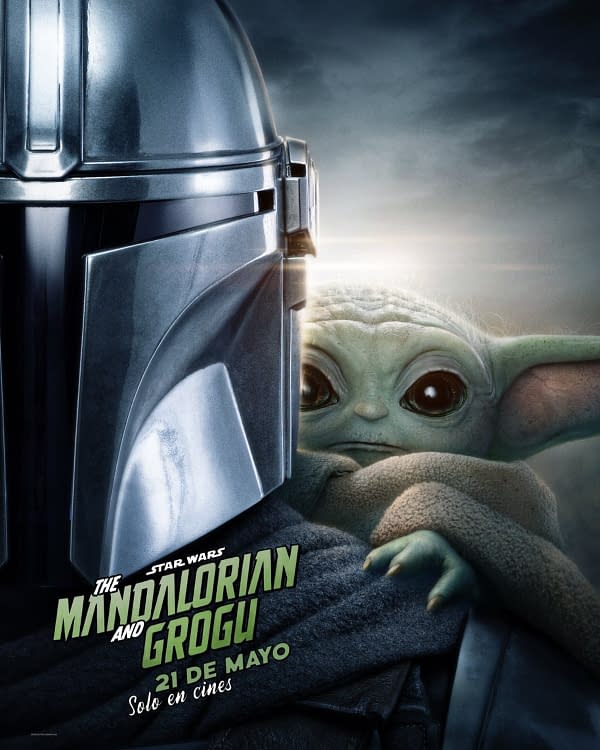 A promotional poster featuring the Mandalorian in a silver helmet next to Grogu, a small green alien with large eyes, wrapped in a dark cloak. The title "The Mandalorian and Grogu" is prominently displayed at the bottom.