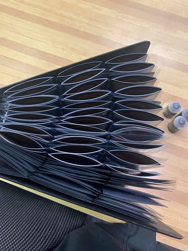 A picture from Reddit, allegedly of a foil-filled Magic: The Gathering binder of Commander Legends cards, all hopelessly arching from curling. Source: Reddit