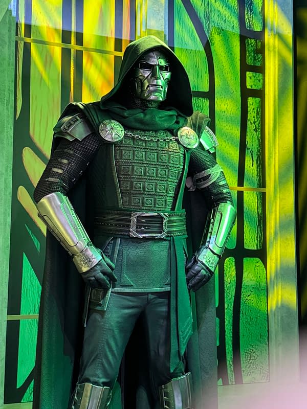 Doctor Doom in a green hood and metal mask, wearing armored black and silver costume at SDCC.