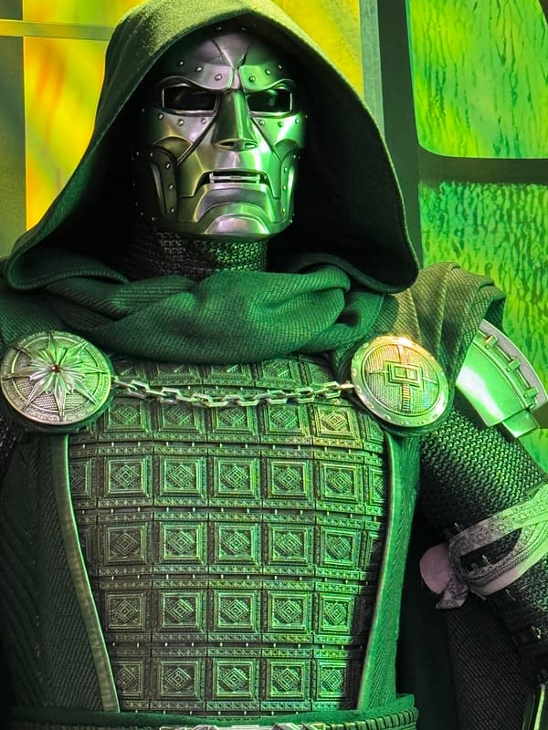 Close-up of Doctor Doom in an ornate green-and-silver costume with a hood and metal mask, likely from Avengers: Doomsday at SDCC.
