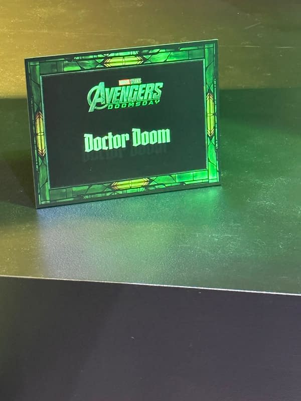 A Marvel Studios Avengers: Doomsday placard with the name Doctor Doom in green lettering, framed by a stained-glass-style border.