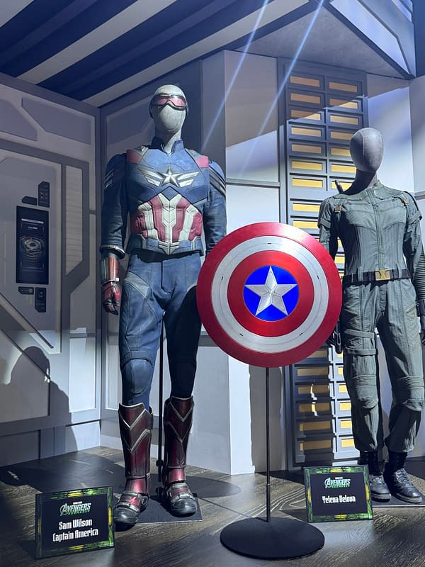 Avengers: Doomsday display at SDCC featuring Captain America's Sam Wilson costume, a Captain America shield, and a Yelena Belova costume on mannequins.