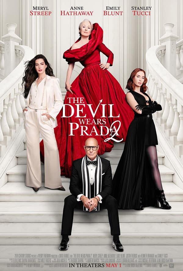 A promotional poster for 'The Devil Wears Prada 2' featuring four main characters styled in fashionable outfits. Meryl Streep, dressed in a striking red gown, stands prominently in the center, flanked by Anne Hathaway in a chic white suit, Emily Blunt in black attire, and Stanley Tucci seated in a tuxedo at the bottom, with a grand staircase in the background.